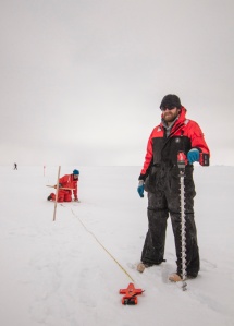 Alice Orlich and Eric Wood measure ice thickness.